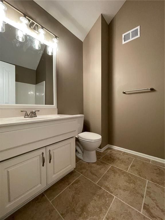 bathroom featuring lofted ceiling, toilet, vanity, visible vents, and baseboards