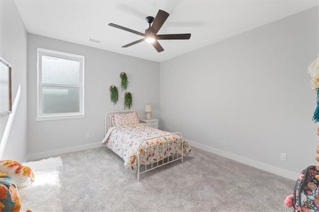 bedroom featuring carpet floors, visible vents, a ceiling fan, and baseboards