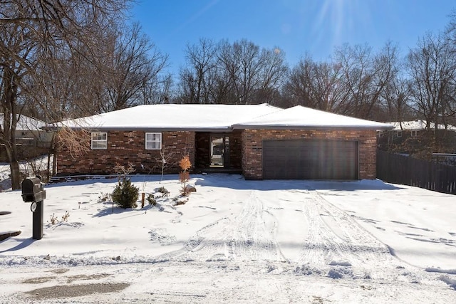 single story home with a garage, brick siding, and fence