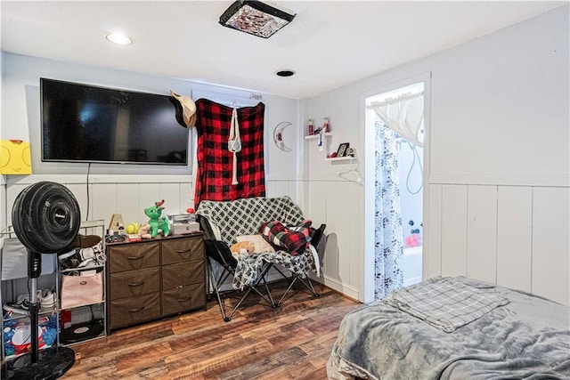 bedroom featuring a wainscoted wall and dark wood-type flooring