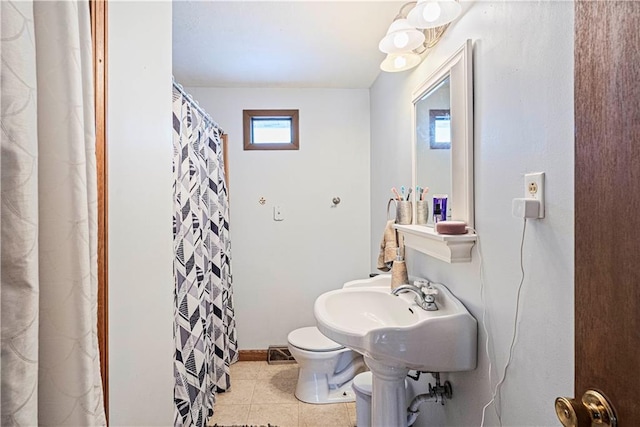 bathroom with toilet, tile patterned flooring, visible vents, and baseboards