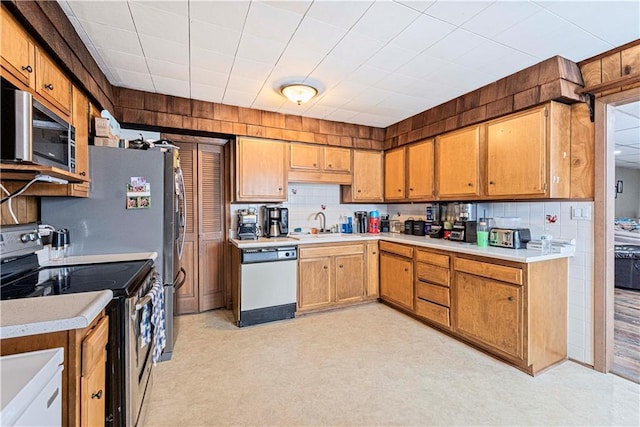 kitchen with brown cabinets, backsplash, stainless steel appliances, and light countertops