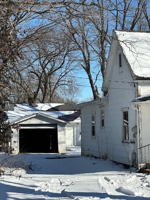 view of snow covered exterior featuring an outbuilding