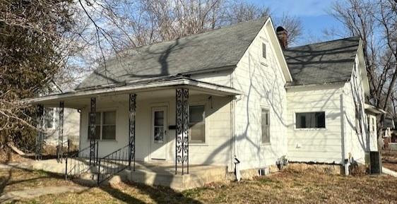 view of front of house with covered porch and a chimney