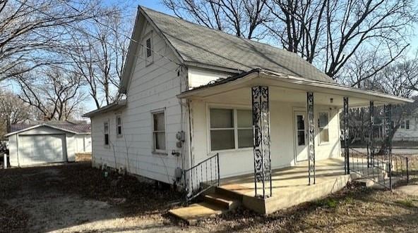 view of front facade with a porch, driveway, and an outdoor structure