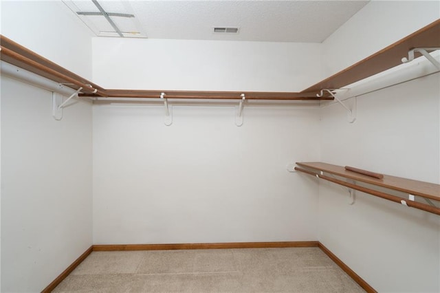 walk in closet with light carpet and visible vents