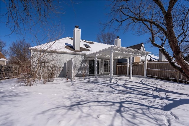 snow covered property featuring fence and a pergola