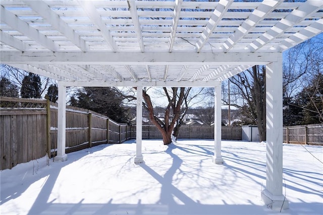 yard layered in snow featuring a fenced backyard and a pergola