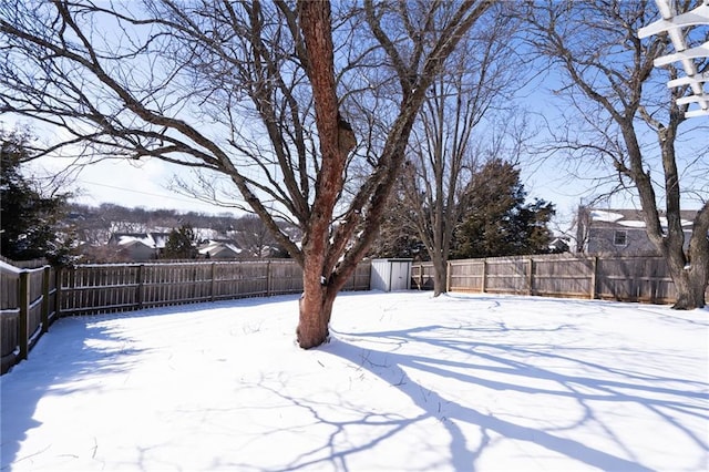 yard layered in snow featuring a fenced backyard