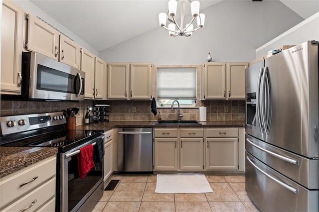 kitchen featuring dark countertops, backsplash, appliances with stainless steel finishes, light tile patterned flooring, and a sink