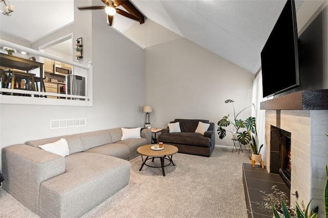 carpeted living area featuring baseboards, visible vents, high vaulted ceiling, a fireplace, and ceiling fan