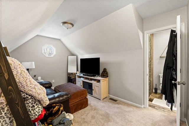 living area featuring light carpet, visible vents, baseboards, and vaulted ceiling