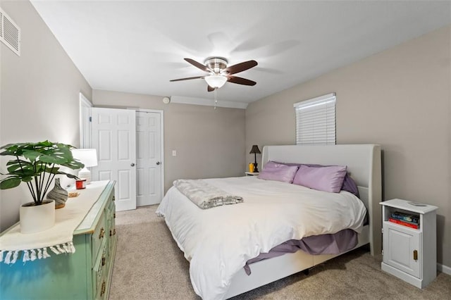 bedroom featuring visible vents, light colored carpet, and ceiling fan