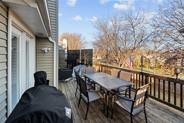 wooden terrace featuring outdoor dining area and a grill