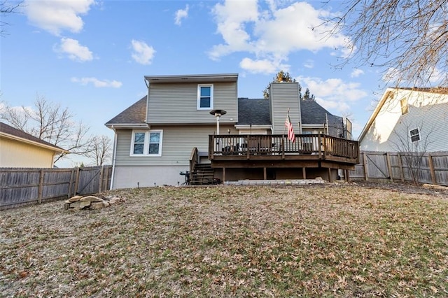 rear view of property with a deck, a shingled roof, a fenced backyard, and a gate