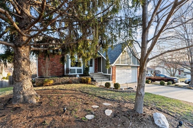 obstructed view of property featuring an attached garage, brick siding, driveway, and roof with shingles