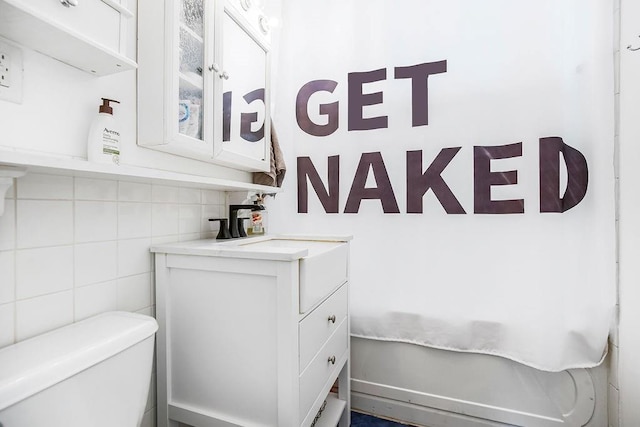 bathroom featuring tile walls, vanity, and toilet