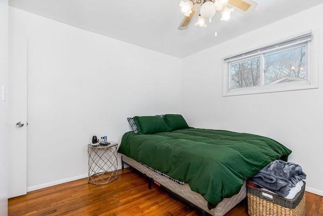 bedroom featuring ceiling fan, wood finished floors, and baseboards