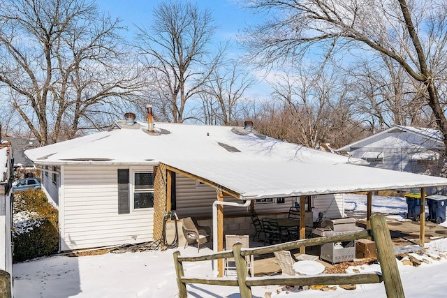 view of snow covered back of property