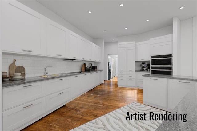 kitchen with stainless steel double oven, dark wood-style flooring, white cabinetry, and a sink