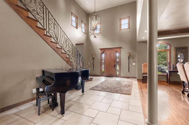 foyer entrance with stairs, a chandelier, and baseboards