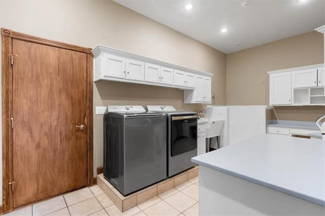 laundry area featuring light tile patterned floors, washer and clothes dryer, cabinet space, and recessed lighting