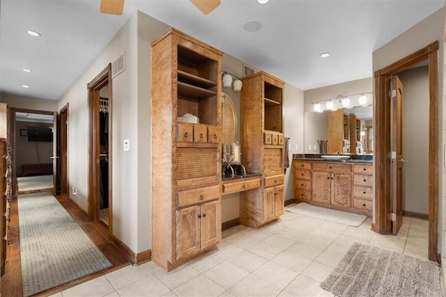 full bathroom with recessed lighting, vanity, baseboards, tile patterned floors, and a walk in closet