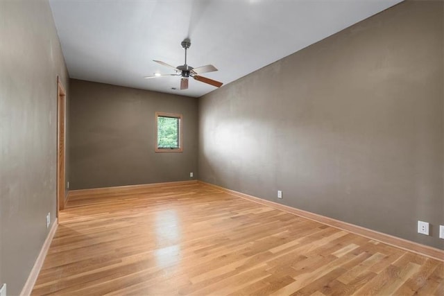 unfurnished room featuring light wood finished floors, ceiling fan, and baseboards