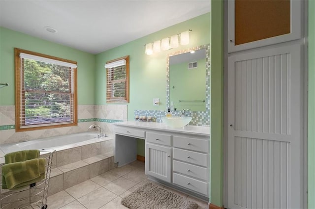 bathroom featuring tile patterned flooring, visible vents, a bath, and vanity