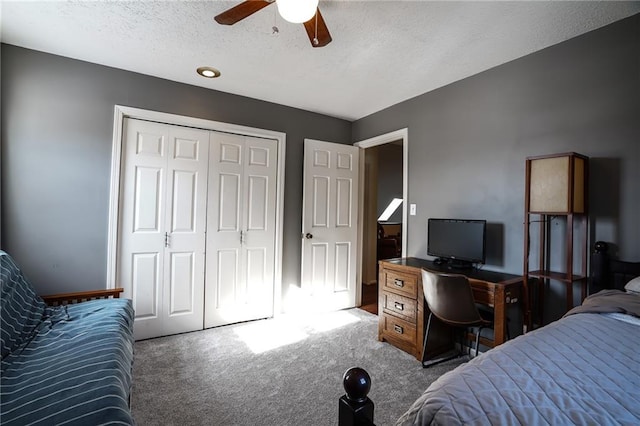 carpeted bedroom featuring ceiling fan, a textured ceiling, and a closet