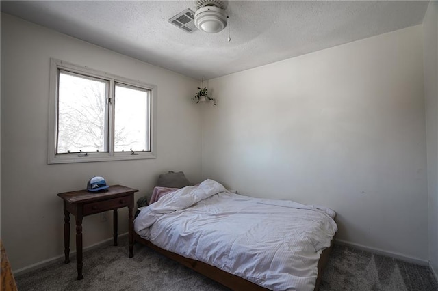 bedroom with visible vents, a textured ceiling, dark carpet, and baseboards