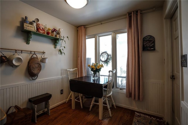 dining space with a wainscoted wall and dark wood-type flooring