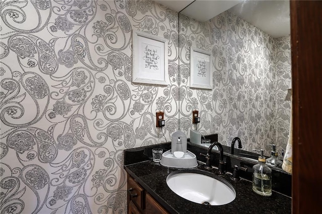 bathroom featuring vanity and wallpapered walls