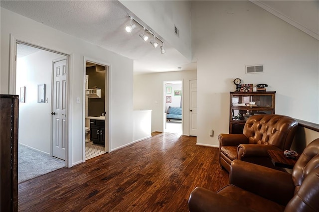 living room featuring rail lighting, baseboards, visible vents, and wood finished floors