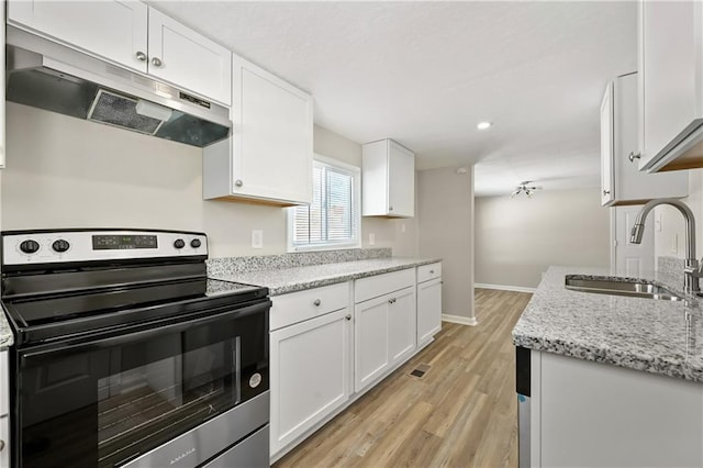 kitchen featuring under cabinet range hood, white cabinets, and electric range