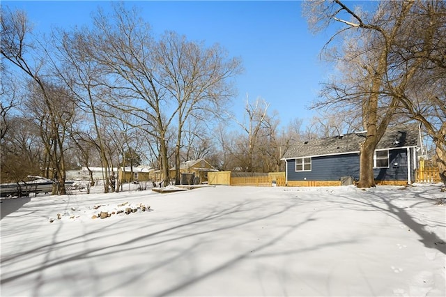 snowy yard featuring fence