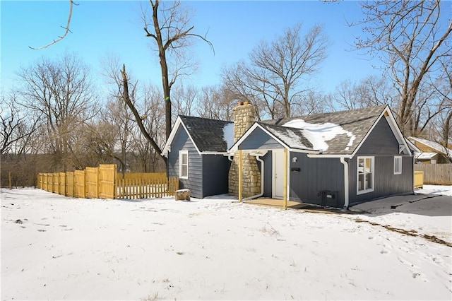 view of front facade featuring a chimney and fence