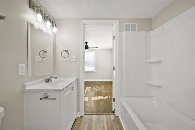 full bathroom with a ceiling fan, wood finished floors, vanity,  shower combination, and visible vents