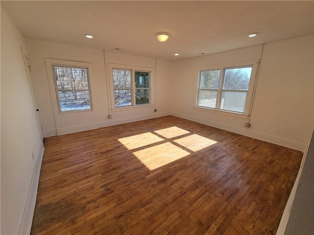 unfurnished room with dark wood-style flooring, recessed lighting, and baseboards