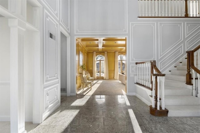 entrance foyer featuring granite finish floor, visible vents, baseboards, and a decorative wall