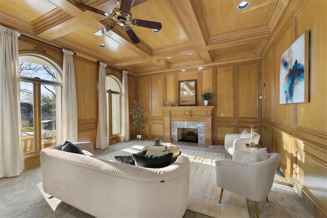 living room featuring coffered ceiling, a high end fireplace, wood ceiling, and a decorative wall