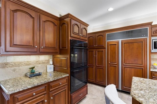 kitchen with tasteful backsplash, light stone countertops, ornamental molding, and built in appliances