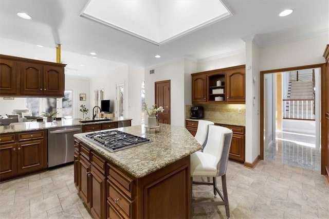 kitchen featuring a kitchen breakfast bar, appliances with stainless steel finishes, a center island, and stone tile floors