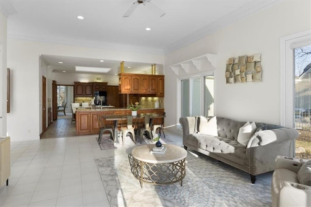 living area with ceiling fan, a wealth of natural light, crown molding, and recessed lighting