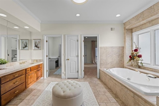 bathroom with stone tile flooring, visible vents, ornamental molding, vanity, and a jetted tub