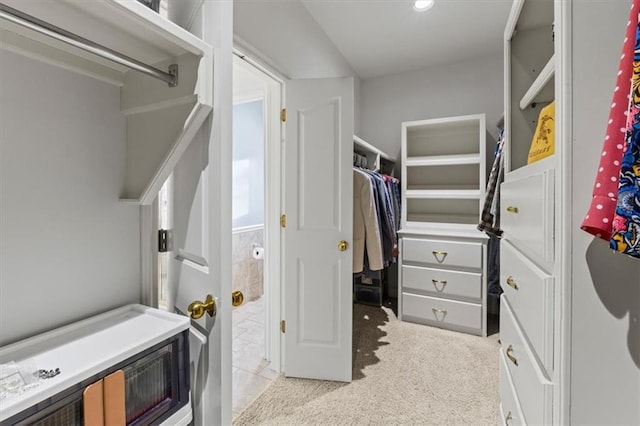 walk in closet featuring light carpet