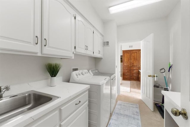 laundry room featuring cabinet space, visible vents, separate washer and dryer, and a sink