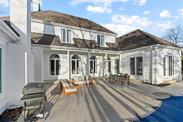 back of property with french doors, stucco siding, a shingled roof, outdoor dining space, and a patio area