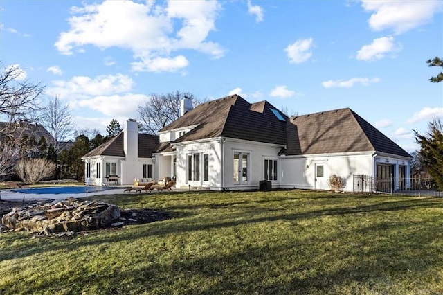 rear view of property featuring a yard, a chimney, and a patio