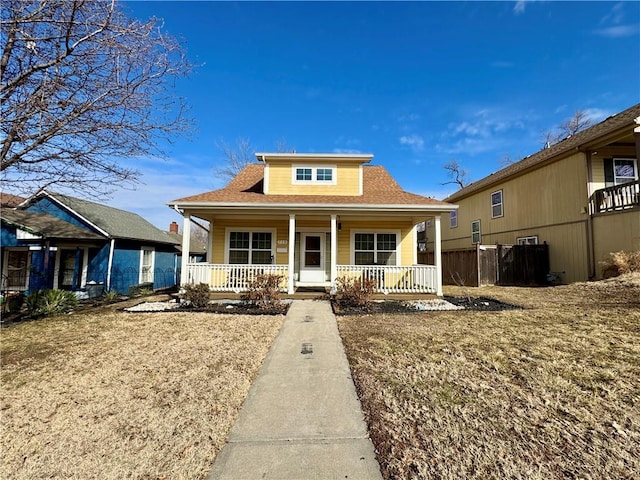 bungalow-style home featuring a porch and fence